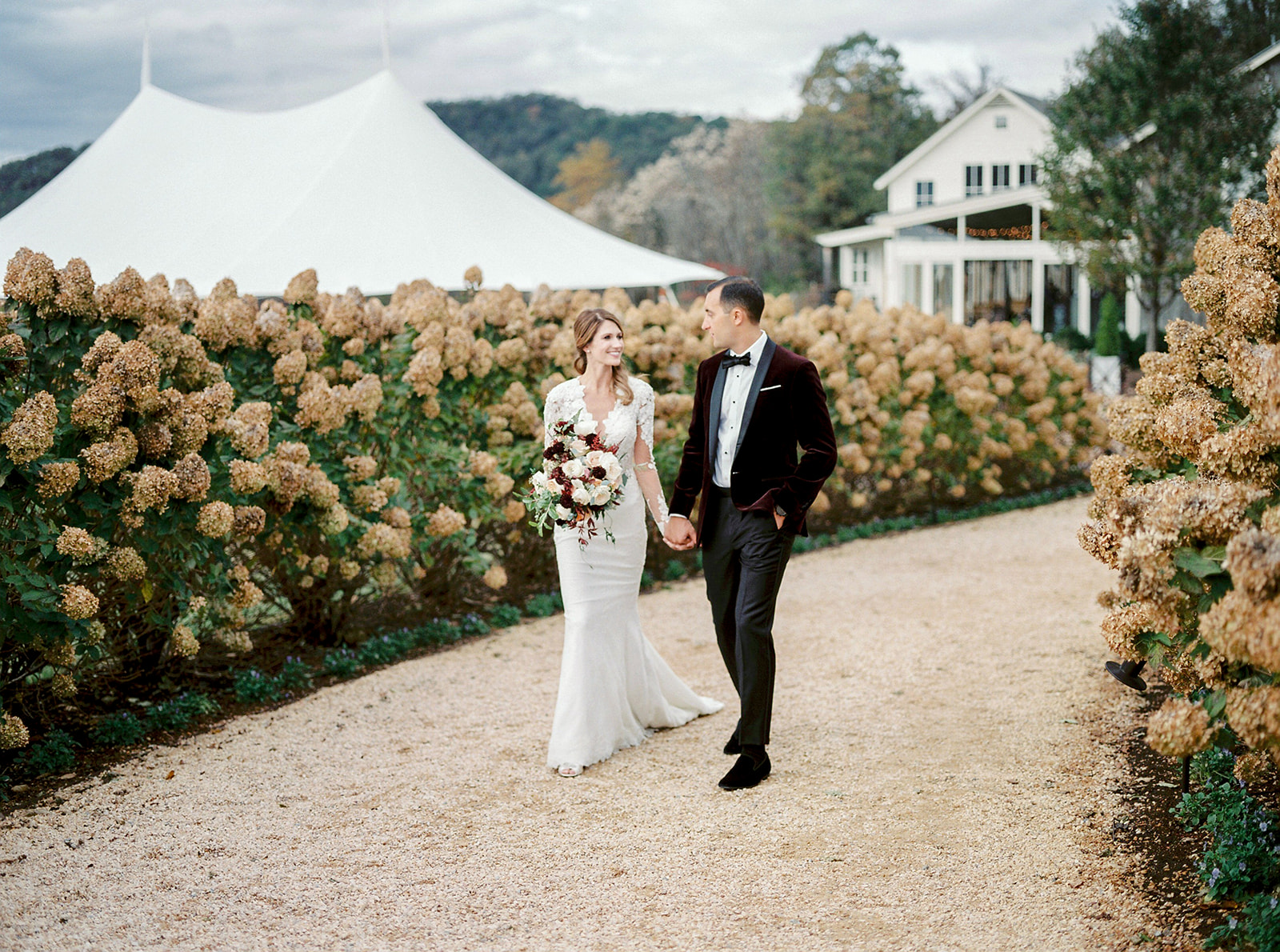 Couple walking down a lane of roses
