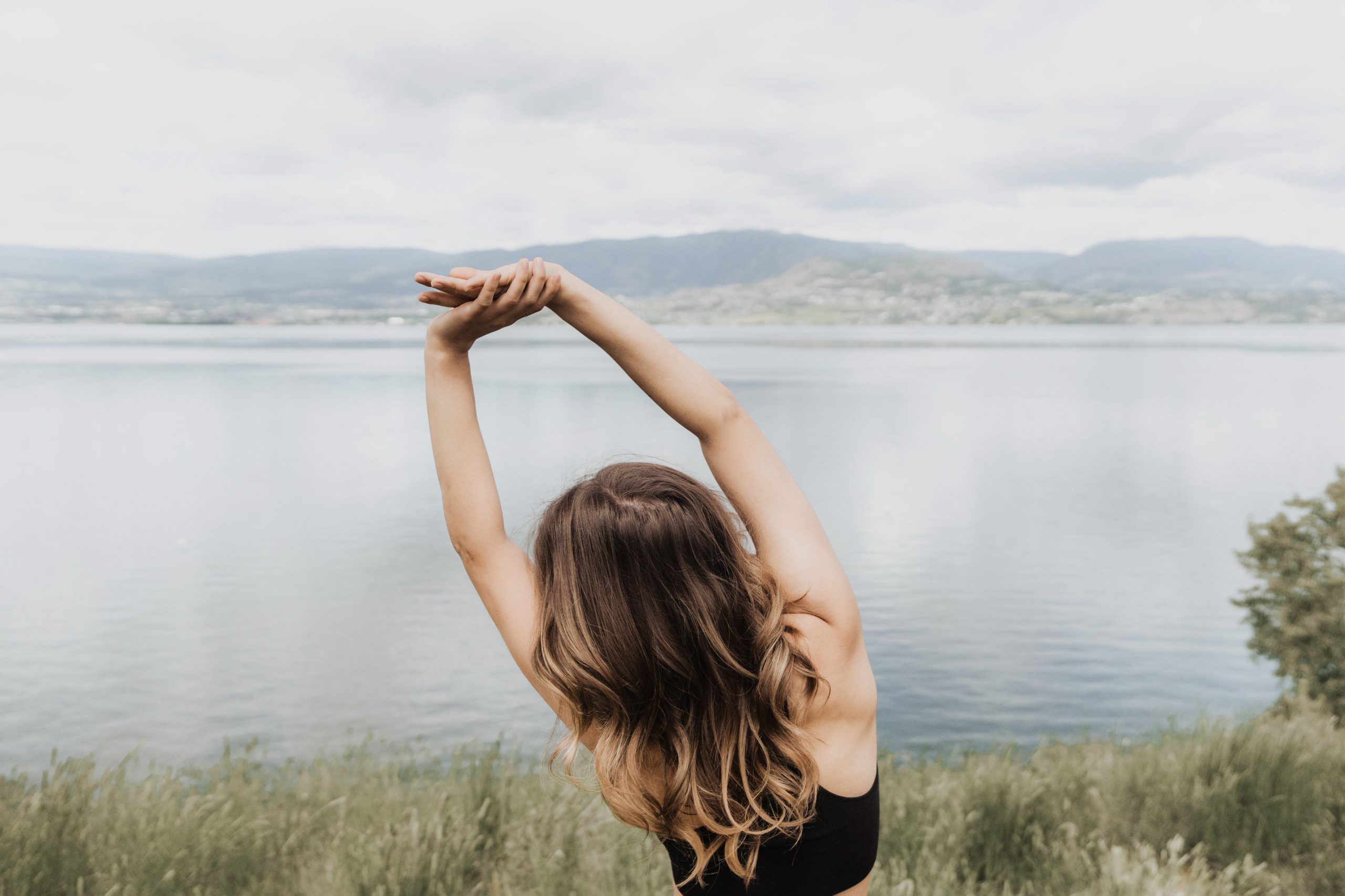 Woman meditating in front of water